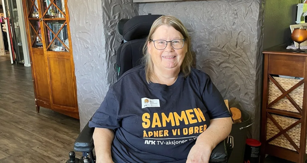 En smilende Anne-Karin iført t-skjorte med årets budskap: «Sammen åpner vi dører»